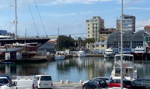 Un grupo de coches aparcados en un puerto deportivo con barcos. en Darsena Charming B&B by Villa Valentina Versilia, en Viareggio