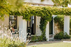 a white house with a green door and ivy at Dove Cottage in Stanford
