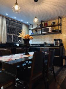 una cucina con un tavolo con un vaso di fiori sopra di Pool amid the green a Gaspar Altre 35 foto