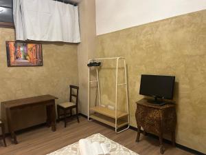 Habitación con cama, TV y escritorio. en Darsena Charming B&B by Villa Valentina Versilia, en Viareggio