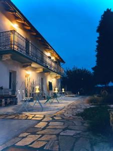 a building with a balcony and chairs in front of it at Suites con Vista Panoramica e Home Restaurant - Pet Friendly nel Monferrato in Cortandone