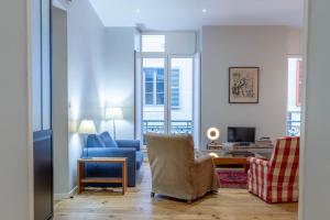 Le Barthou - T3 lumineux en centre-ville de Pau في بو: غرفة معيشة مع كرسي أزرق وأريكة