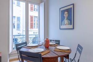 Le Barthou - T3 lumineux en centre-ville de Pau في بو: طاولة طعام مع كراسي و لوحة على الحائط