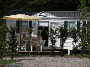 a couple sitting at a table on the porch of a house at ZEcamping 4 étoiles parc aquatique restaurant et parcours de pêche au fouet in Argentat
