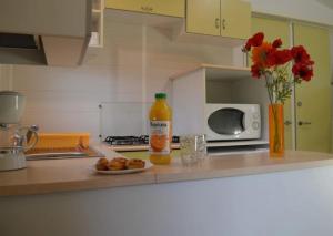 a bottle of orange juice and a plate of food on a kitchen counter at ZEcamping 4 étoiles parc aquatique restaurant et parcours de pêche au fouet in Argentat