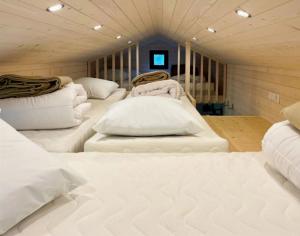 een kamer met vier witte bedden in een kamer bij Cabane 3 étoiles - ccbechc in Neuilly-sur-Marne