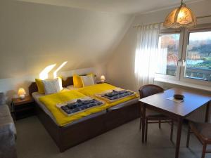 a bedroom with a bed with yellow sheets and a table at Schwanensee App 04 in Göhren