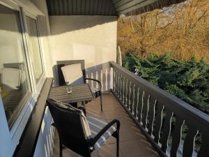 a balcony with chairs and a table and a laptop at Schwanensee App 04 in Göhren