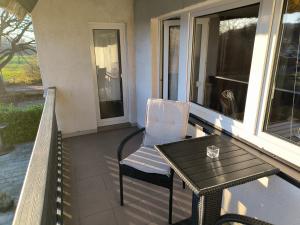a porch with a table and a chair and a table and a tableearcher at Schwanensee App 04 in Göhren