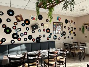 a dining room with tables and records on the wall at Brit Hotel Reims La Pompelle in Reims
