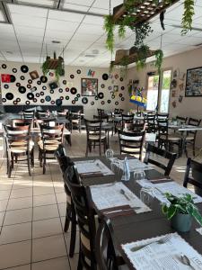 a restaurant with tables and chairs and a wall with plates at Brit Hotel Reims La Pompelle in Reims