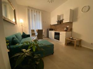 a living room with a green couch and a kitchen at Il Campanile 2 in Fondi