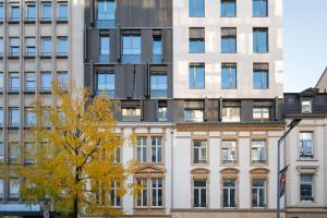 卢森堡The Central City - Luxury Serviced Residence的一座高大的白色建筑,有窗户和树