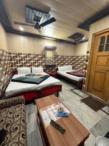 een kamer met twee bedden en een tafel erin bij Hotel Aditya Sheraton in Haridwār