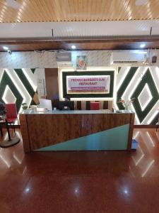 a lobby with a reception desk with a sign on the wall at Trishan Hotel in Dhupguri