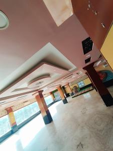 an empty living room with a ceiling and windows at Trishan Hotel in Dhupguri