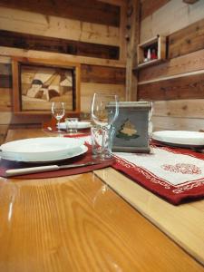 una mesa de madera con platos y vasos. en Botton d'oro, en Campitello di Fassa