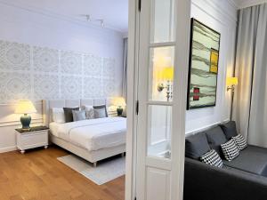 a white bedroom with a bed and a couch at Luxury Apartments MONDRIAN Market Square III in Warsaw