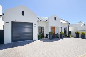a white house with a garage at Caracal 54 in Yzerfontein