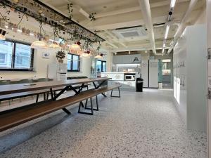 a large room with tables and a kitchen at The Cube Hotel in Seoul