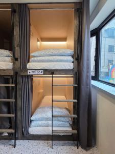 twee stapelbedden in een kamer met een raam bij The Cube Hotel in Seoul
