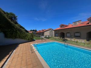a swimming pool in front of a house at Balcón del Cantábrico in Comillas