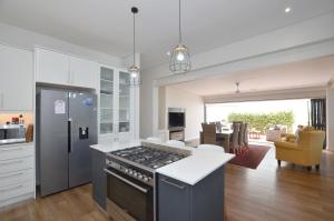 a kitchen with a stove top oven next to a living room at Caracal 54 in Yzerfontein