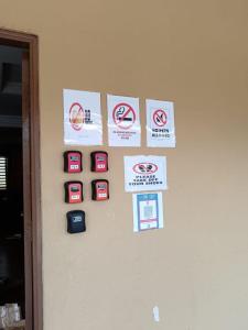 una pared con letreros colgando de una pared en Bahagia Court Homestay, en Temerloh