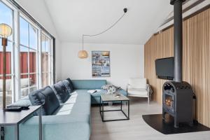 Feriehus 3007 في Nørre Lyngvig: غرفة معيشة مع أريكة زرقاء وموقد