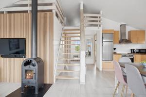 Feriehus 3007 في Nørre Lyngvig: غرفة معيشة مع موقد ومطبخ