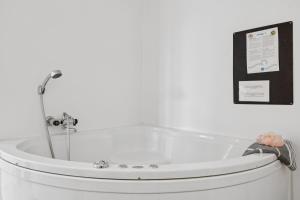 Feriehus 3007 في Nørre Lyngvig: حوض استحمام في الحمام مع وضع علامة على الحائط +26 صورة