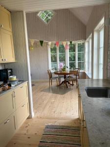 Architect-Designed Cabin With Lake View In Hindås في Hindås: مطبخ وغرفة طعام مع طاولة وكراسي
