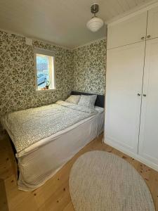 Architect-Designed Cabin With Lake View In Hindås في Hindås: غرفة نوم بسرير مع نافذة وسجادة