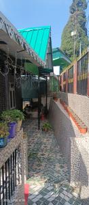 Songden Homestay في Kurseong: مبنى ذو مظلة خضراء وفناء