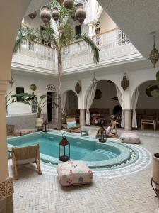 a swimming pool in a building with a palm tree at Riad Zayn & Spa in Marrakesh