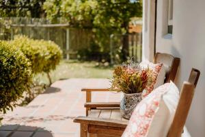 a vase of flowers sitting on a bench on a porch at Finchlea Cottage in Stanford