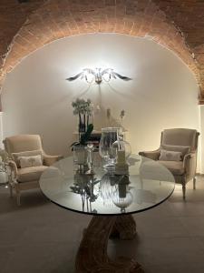 a living room with a glass table and two chairs at My Maison 49 in Empoli