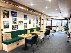 a restaurant with a green couch and tables and chairs at Suite in Dream Bansko in Bansko