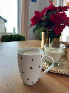 Domek na Wielkiej Górze في Waksmund: وجود كوب من القهوة على طاولة مع الزهور +34 صورة