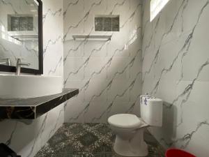 a bathroom with a white toilet and a sink at Penginapan Mafir in Tuk Tuk