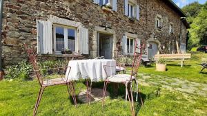 a table and chairs in front of a stone house at Chambre Grande Ourse, La maison sous les étoiles in Combelle +14 photos