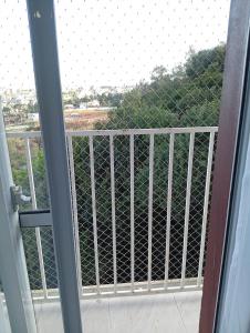 Una puerta abierta a un balcón con valla. en Apartamento dentro da ucs universidade, en Caxias do Sul