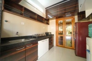 The Royal Villa في بانتشجانى: مطبخ مع خزائن خشبية ومغسلة