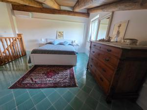 a bedroom with a bed and a dresser and a rug at Casale Dionisia, Santa Maria di Castellabate in Castellabate