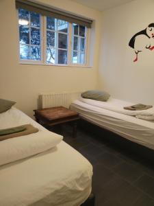 a room with three beds and a window at Selfoss Hostel in Selfoss