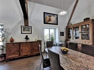 una sala da pranzo con tavolo e sedie in legno di Chambre Romantique, Le Suc du Pommier a Grazac