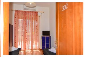 a living room with a curtain and a door with a television at La Dolce Sosta in Lido di Ostia