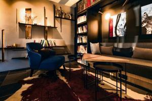a library with a blue chair and a table and books at CitiGO Hotel, South Gate of Xi'an Bell Tower in Xi'an