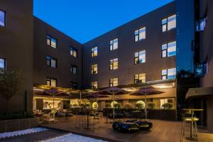 a hotel with tables and umbrellas in front of a building at CitiGO Hotel, South Gate of Xi'an Bell Tower in Xi'an