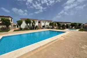 a large swimming pool in front of a house at Forcat - Apartamento con jardín y piscina in Ciutadella